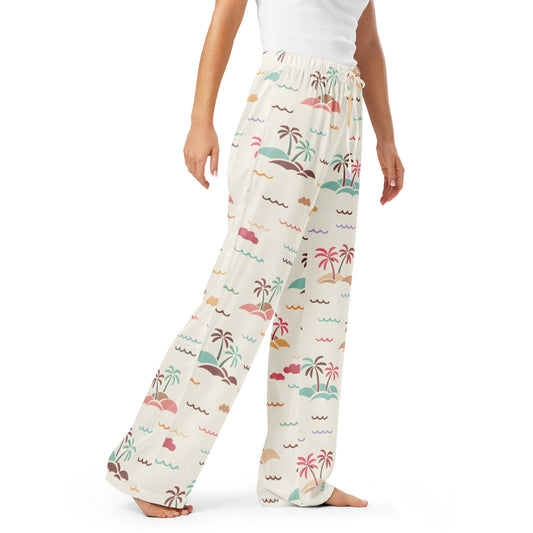 Woman wearing the Vibewear 'Sorbet Shores' satin pajama pants, highlighting the colourful abstract pattern and relaxed straight-leg fit.