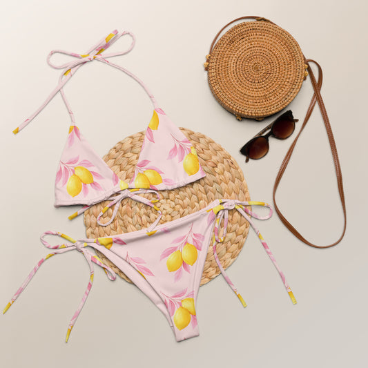 Lemon Tree recycled string bikini with lemon print laid flat with summer accessories