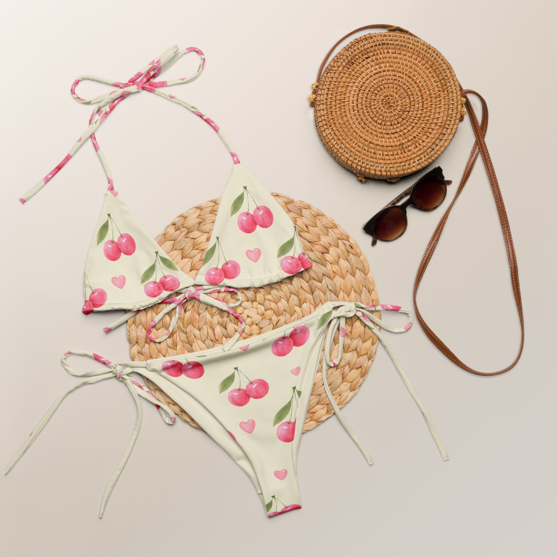 Sweet Cherry Crush recycled string bikini laid flat with summer accessories