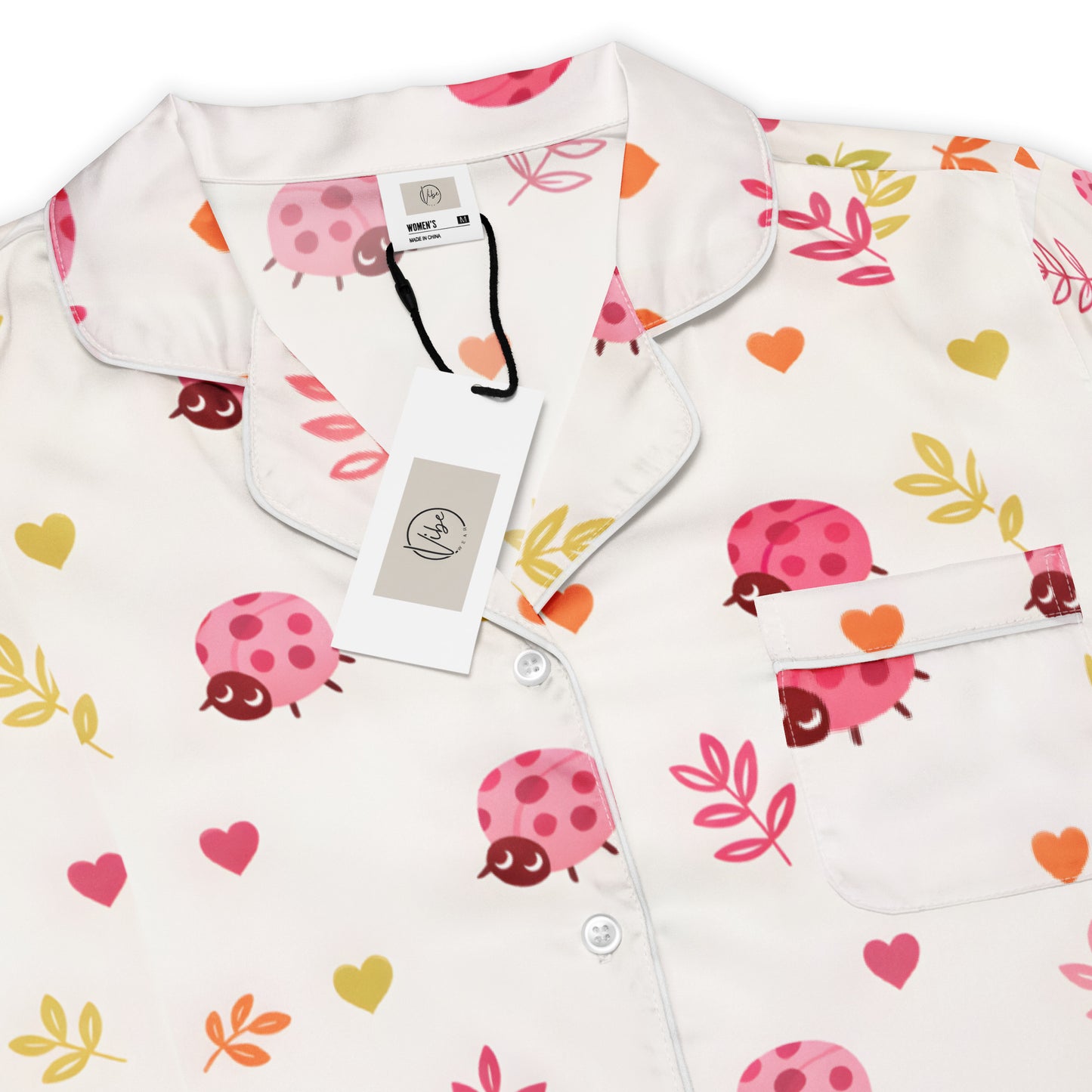 Woman wearing the Vibewear 'Ladybird Daydream' long sleeve satin pajama top, showing the cute red ladybug pattern and classic button-front style.