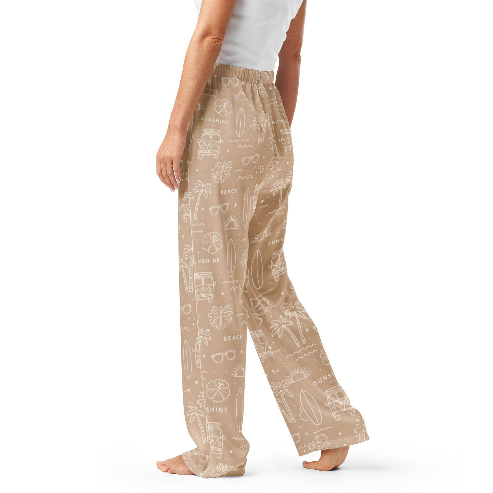 Woman wearing the 'Coastal Daydream' satin pajama pants, highlighting ocean pattern and the relaxed, straight-leg fit.