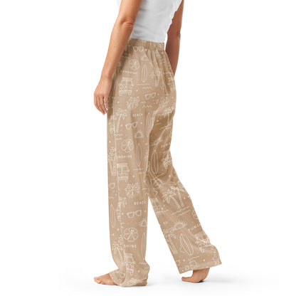 Woman wearing the 'Coastal Daydream' satin pajama pants, highlighting ocean pattern and the relaxed, straight-leg fit.