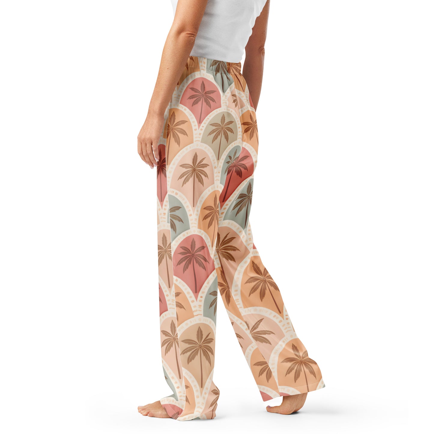 Woman wearing the Vibewear 'Sunset Palm Mosaic' satin pajama pants, highlighting the intricate blue and orange geometric pattern and the relaxed, straight-leg fit.