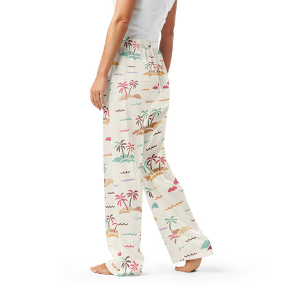 Woman wearing the Vibewear 'Sorbet Shores' satin pajama pants, highlighting the colourful abstract pattern and relaxed straight-leg fit.
