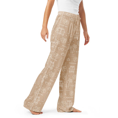 Woman wearing the 'Coastal Daydream' satin pajama pants, highlighting ocean pattern and the relaxed, straight-leg fit.