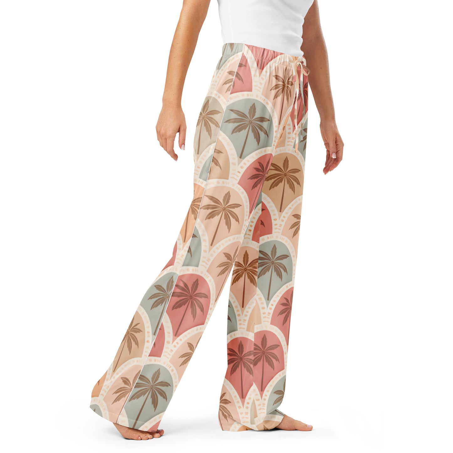 Woman wearing the Vibewear 'Sunset Palm Mosaic' satin pajama pants, highlighting the intricate blue and orange geometric pattern and the relaxed, straight-leg fit.