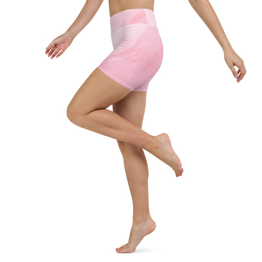 Side view of model wearing pink high waist yoga shorts showing stretch and movement