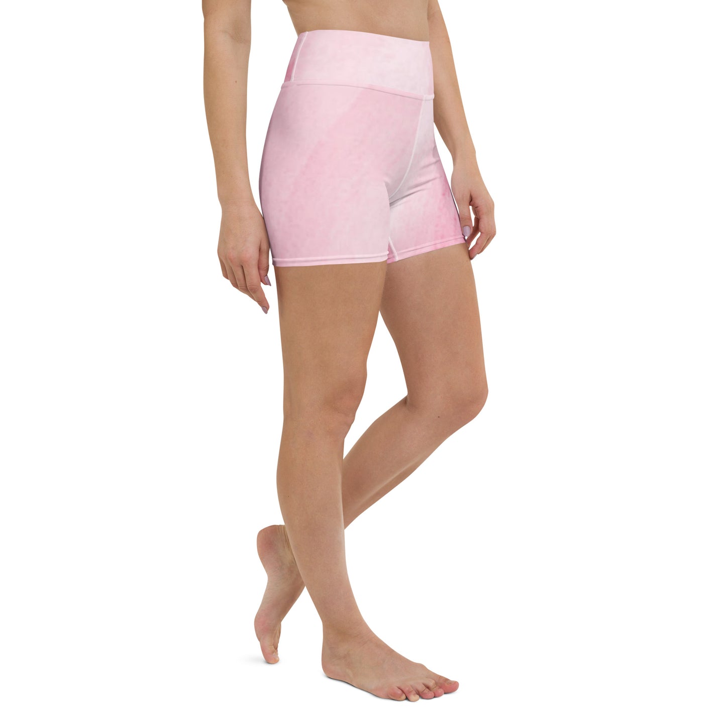 Side view of model walking in pink high waist yoga shorts showing full length fit