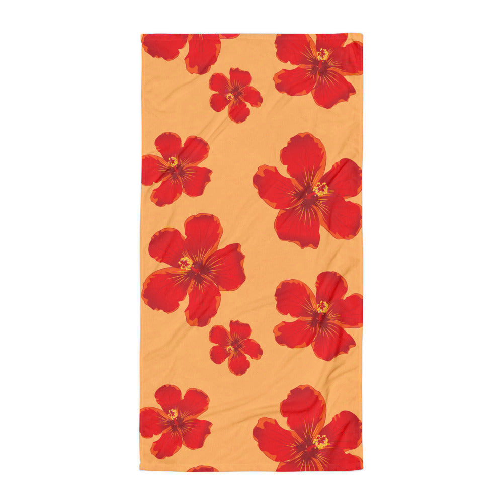 Red floral bath and beach towel with warm sunset background