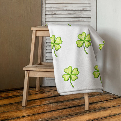 Lucky Clover bath or beach towel with four leaf clover print hanging indoors