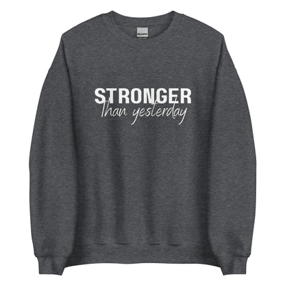 The 'Stronger Than Yesterday' classic sweatshirt shown in dark grey marle, with the motivational slogan printed in a bold, white, distressed font across the chest.