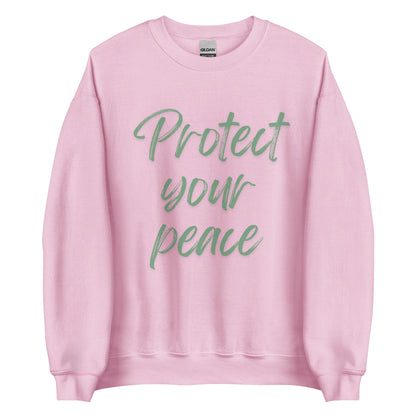 The 'Protect Your Peace' classic sweatshirt shown in pink, with the slogan printed in a green retro-style font 